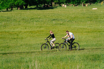 Two people with their baby riding on car track in a countryside