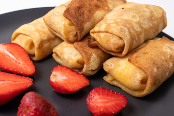 Wheat flour pancakes with strawberries. Sweet homemade pastries for breakfast. With sugar.