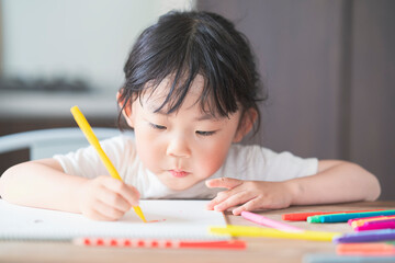 ダイニングテーブルでお絵かきをする子ども