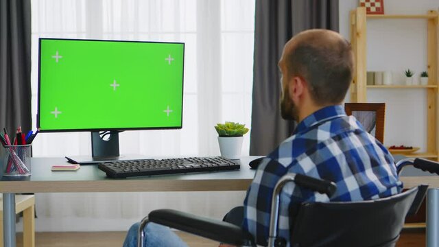 Handicapped man in wheelchair talking with computer. Handicapped invalid paralysed freelancer, immobilized entrepreneur working from home, ilness and disability