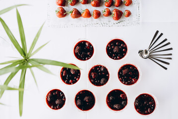 Festive table with white tablecloths, plant in a pot, glasses with panna cotta or dessert with...