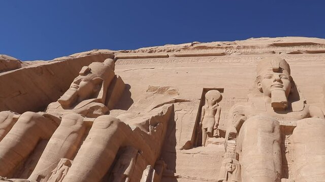 Colossal Statues of Ramesses II and statue of ancient Egyptian deity of the sun.