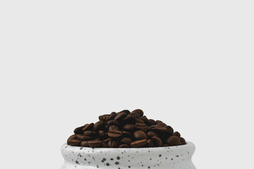 Lots of coffee beans stacked in a white Cup. Minimalistic style