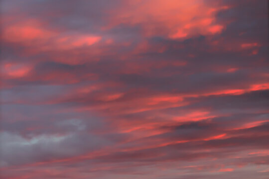Colorful pink orange sunset sky with thick clouds © yta