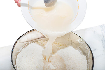 Close-up of a liquid base for dough that is poured into flour