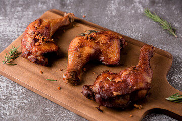 Fried chicken on a wooden tray topped with fried garlic