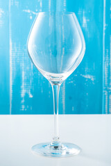 Cold summer delicious coctail with lime and ice in a glass with drops on the white and blue background.