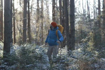 winter landscape forest backpack man / traveler in modern winter clothes in the forest, traveling in the mountains  europe, switzerland winter