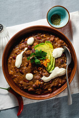vegan chili soup without meat, with pinto beans and avocado, served with yogurt made from soy on...