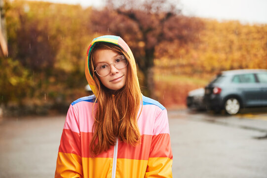 Outdoor Portrait Of Pretty Young Girl Wearing Colorful Rain Coat