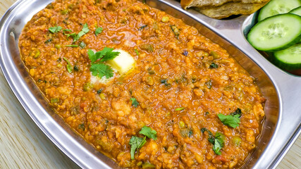 Delicious Pav Bhaji with butter on top in a steel plate like Mumbai street food