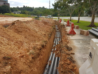 SEREMBAN, MALAYSIA -AUGUST 01, 2019: Underground utility and services pipe laid by workers in the...