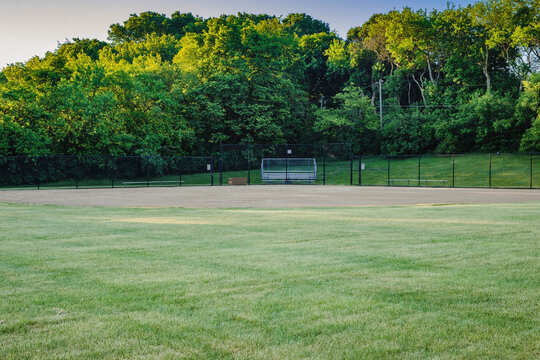 the the view from the outfield of a youth baseball field in a city park