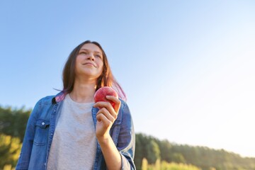 Young happy woman with red apple, girl biting an apple