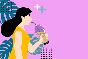 A woman In yellow  shirt is drinking bubble milk tea. She is on pink background and monstera leaves.
