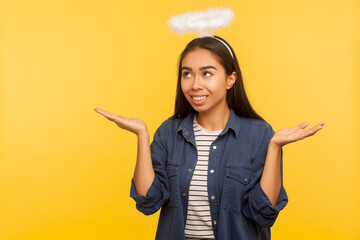 I am saint! Portrait of angelic girl with nimbus over head raising hands with blessing and glory...