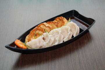 Fried and steamed dumplings in boat shaped bowl