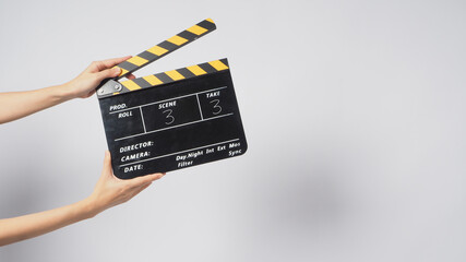 A Hand is holding Black&yellow clapperboard or movie slate on white background.It has written a number.. - obrazy, fototapety, plakaty