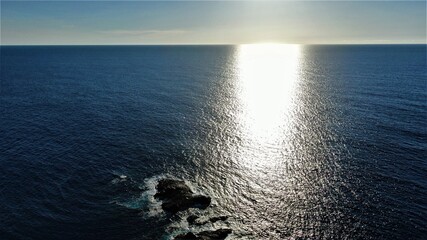 on the cliffs by the sea and the mountains watching the sunset