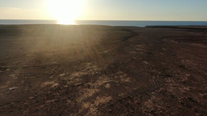 on the cliffs by the sea and the mountains watching the sunset