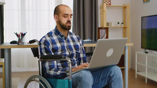 Invalid freelancer in wheelchair working remotely on laptop. Handicapped invalid paralysed freelancer, immobilized entrepreneur working from home, ilness and disability