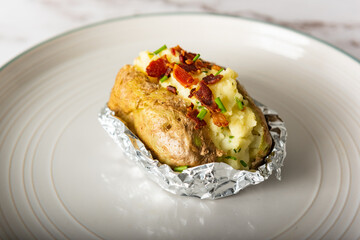 Home cooking jacket potato, filled with sour cream, bacons and chives