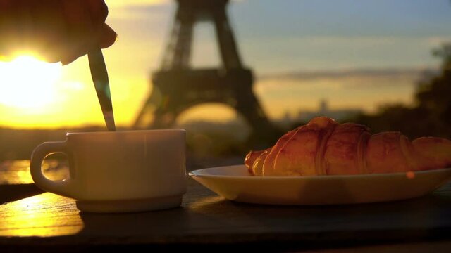 Cup of fresh morning coffee with croissant on the background of the Eiffel Tower, Paris, France