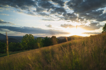 Naklejka na ściany i meble Hügel in Landschaft bei Sonnenuntergang und wolkigem Himmel in Rynartice, Sächsische Schweiz