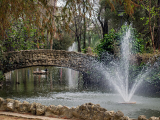 Fountain and stone bridge on the island of the ducks located within the Parque de María Luisa,...