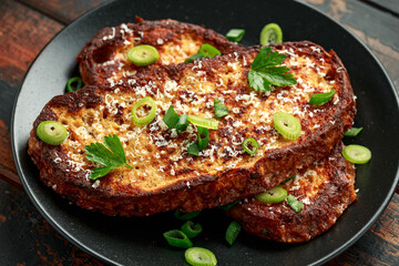 Parmesan cheese French Toast with spring onion on black plate