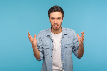 Aggression and conflict. Portrait of irritated man in worker denim shirt raising hands and...