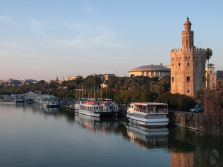 Fototapeta na wymiar View of the Torre del Oro reflected in the Guadalquivir river and behind the Maestranza Theater, Seville, Andalusia, Spain