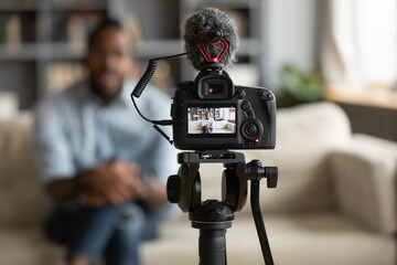 African man blogger sit on sofa record new vlog view through digital camera screen close up....