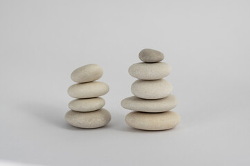Fototapeta na wymiar Two simplicity stones cairn isolated on white background, group of four and five white pebbles in tower
