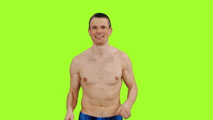 Handsome young man with naked torso jogging on green screen background, Front view, Chroma key