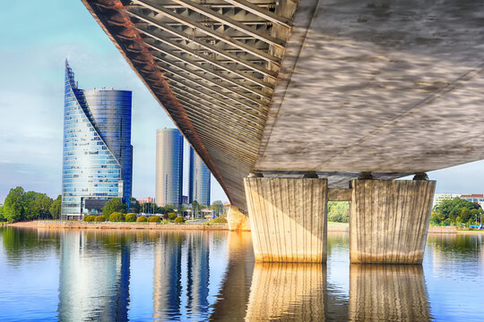 View under Vansu bridge in Riga, Latvia. Modern building (left) and pillars of the bridge (right)