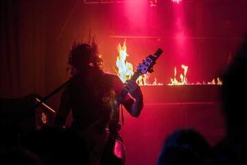 Krakow, Poland - September 20, 2014: An abstract of a man perform rock thrash metal music with a guitar and flame at the background