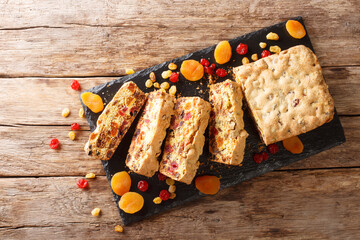 Sliced sugarless fruit cake with dried apricots berries raisins figs cherries closeup on a slate board. Horizontal top view
