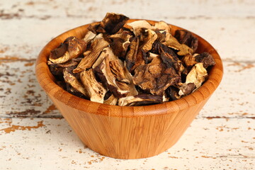 Dried mushrooms in wooden bowl. Boletus badius.