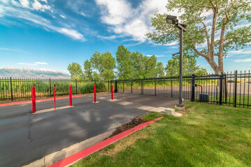 Private property with security gate against snow capped mountain and blue sky
