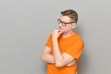 Portrait of serious man touching chin with hand and thinking
