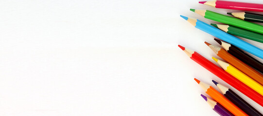 Colored pencils on white background. Lots of different colored pencils. Colored pencil. Pencils sharp. Pencils lie on right. Beautiful background. Close-up. Copy space. Background. Flatlay. Banner