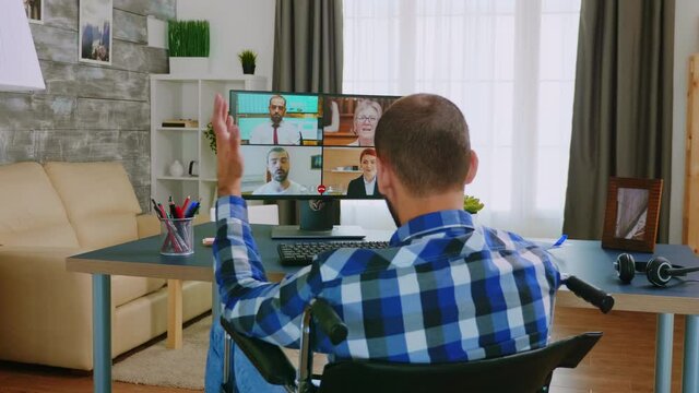 Disabled man in wheelchair during a video call with colleagues. Handicapped invalid paralysed freelancer, immobilized entrepreneur working from home, ilness and disability