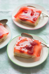 Sponge cake with yoghurt and lemon layers with strawberries and jelly 