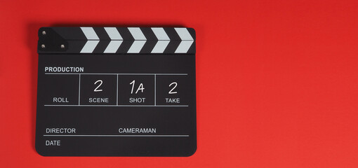 Fototapeta na wymiar Clapperboard or movie slate. It is used in video production, film, cinema industry on a red background.