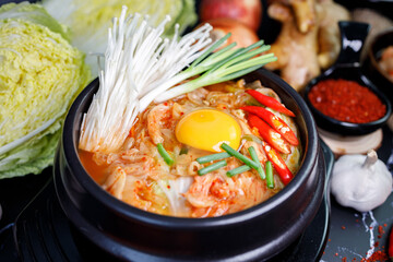 Kimchi cabbage soup in a bowl with materials of the kimchi on black background
