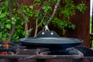 the cook roasts the cutlets in a pan over the fire. food on the grill in nature. picnic.