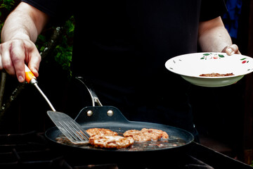 the cook roasts the cutlets in a pan over the fire. food on the grill in nature. picnic.