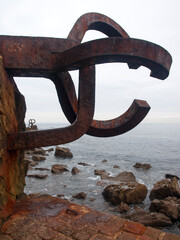 Horizontal view of the sculpture "Peine del Viento", with the Cantabrian Sea in the background on a winter day, San Sebastián, España