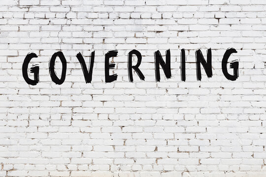 White wall with black paint inscription governing on it